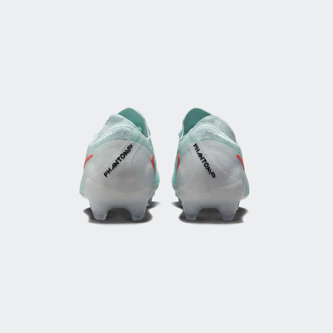 Pair of light mint green Nike Phantom Gx 11 Club Fg/Mg soccer boots with orange accents, shown from the rear view.