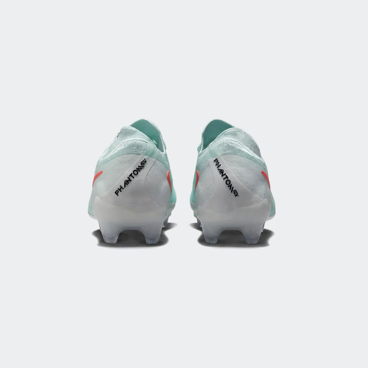 Pair of light mint green Nike Phantom Gx 11 Club Fg/Mg soccer boots with orange accents, shown from the rear view.