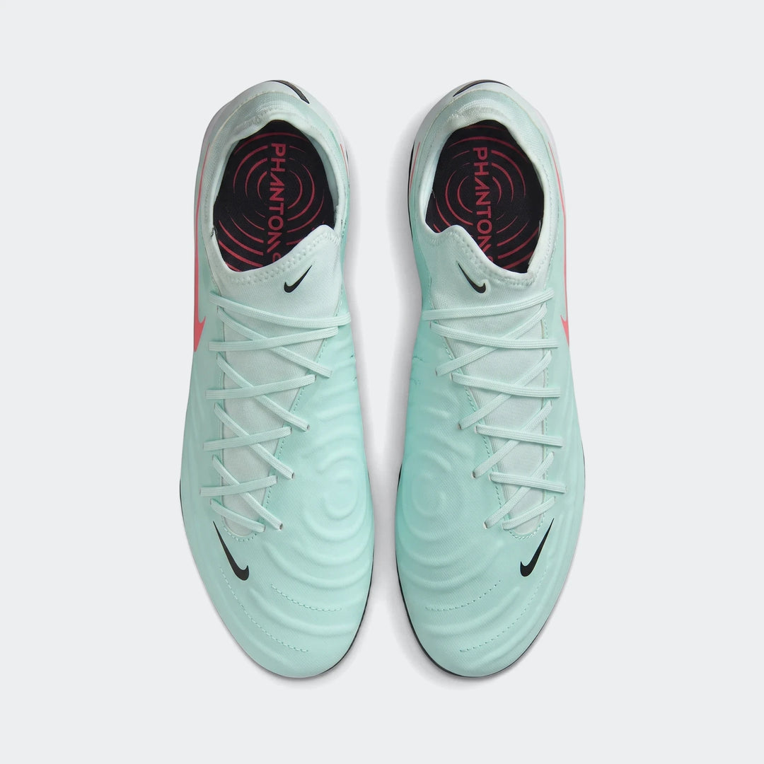 A pair of light green Nike Phantom Gx 11 Club Fg/Mg football boots, featuring black swooshes and laces, shown from a