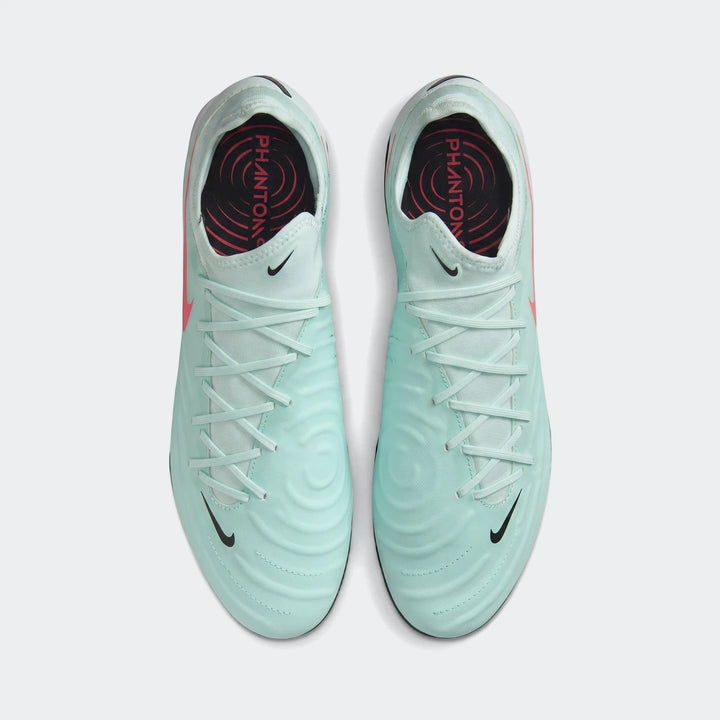 A pair of light green Nike Phantom Gx 11 Club Fg/Mg football boots, featuring black swooshes and laces, shown from a