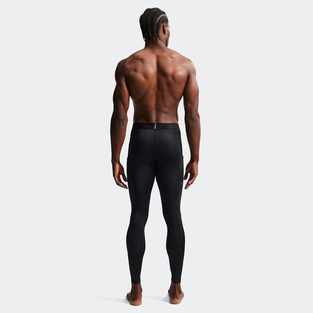 Black Nike Pro Men's Dri-Fit fitness tights modeled from the back on a man with braided hair, full body view.