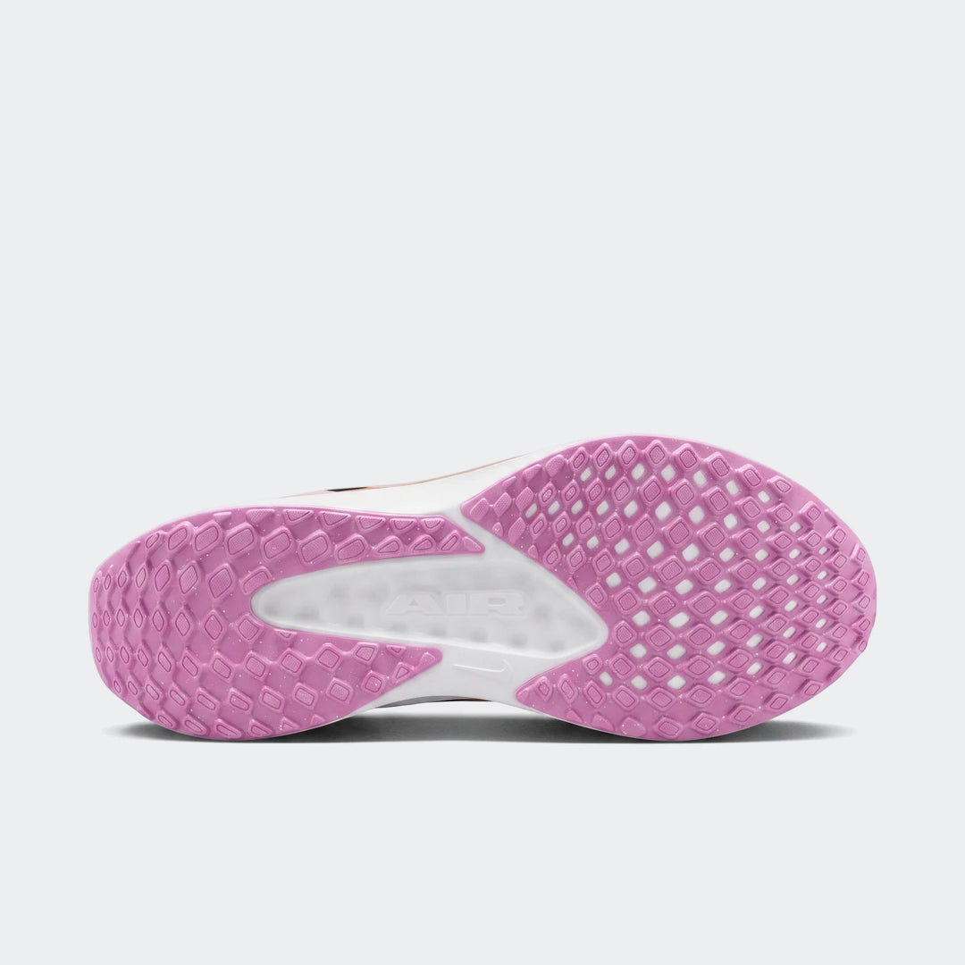 Underside view of a Nike Quest 6 White sneaker, showcasing the pink textured outsole and white midfoot with "AIR" branding