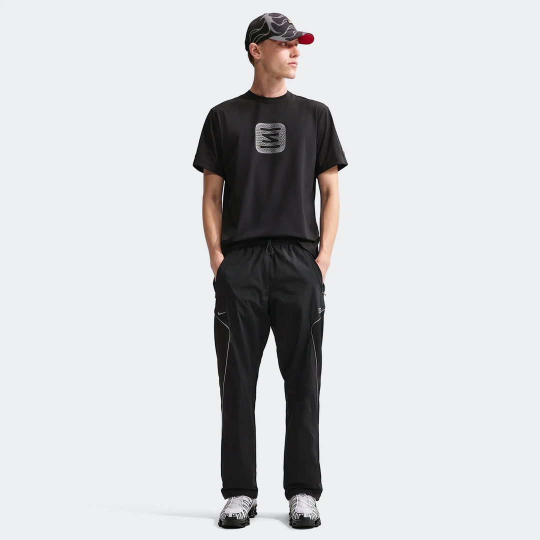 Mens Core Black Nike Shox T-Shirt with white graphic, paired with black athletic pants, patterned cap, and sneakers on a