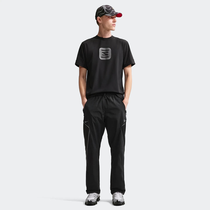 Mens Core Black Nike Shox T-Shirt with white graphic, paired with black athletic pants, patterned cap, and sneakers on a