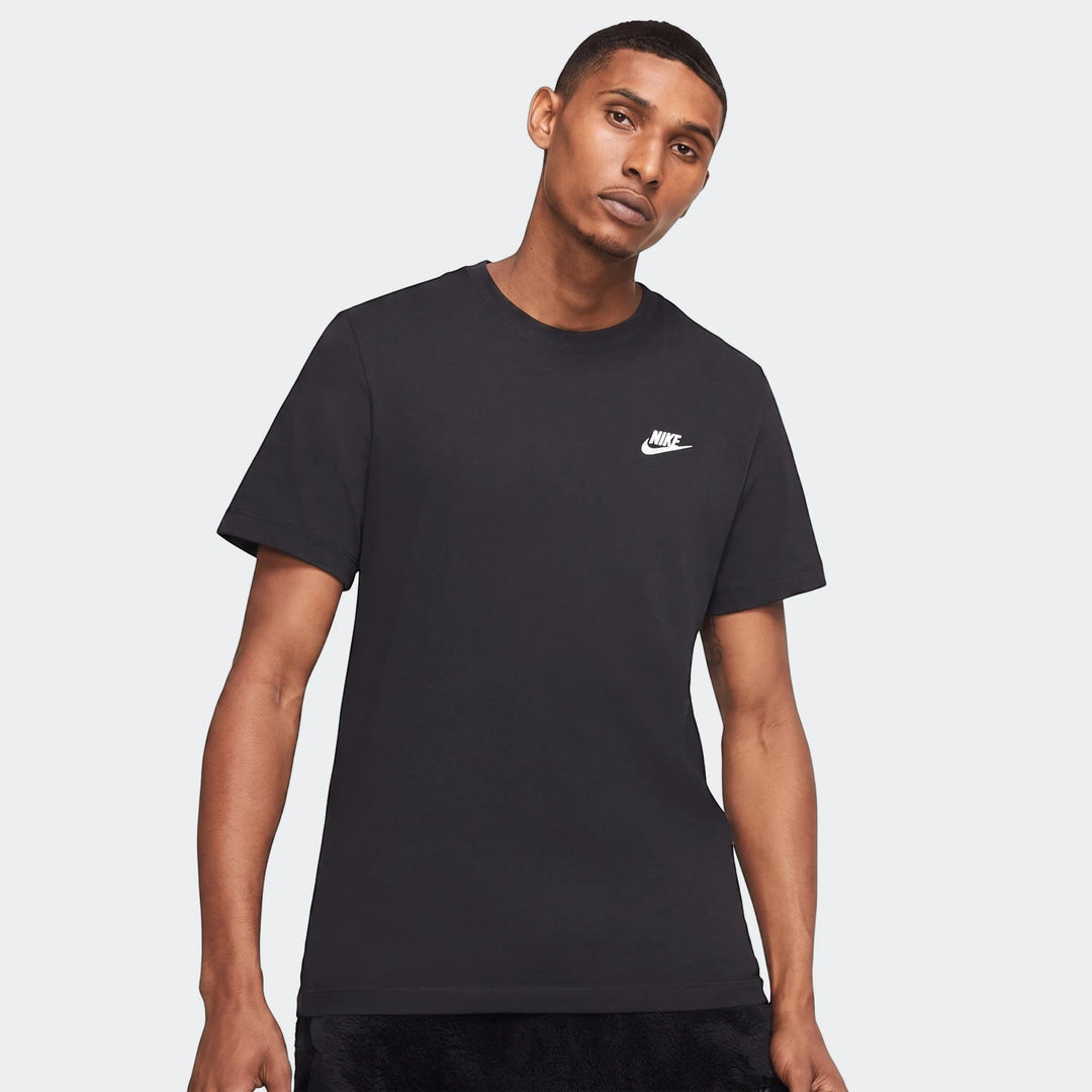 Man wearing a black Nike Sportswear t-shirt with a white swoosh logo on the chest, studio shot.
