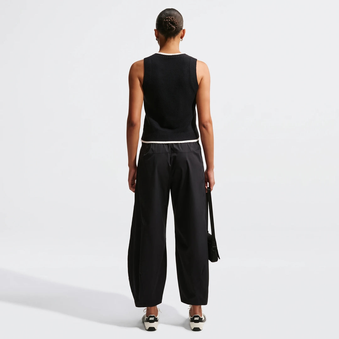 Black Nike Sportswear Chill Knit Women's Loose Sweater Vest and black wide-leg cargo pants with Nike sneakers, full body