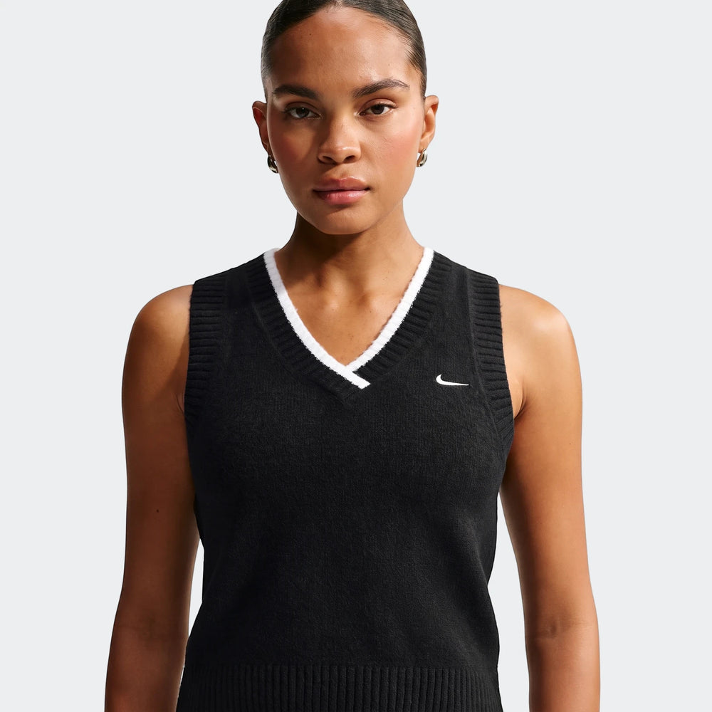 Woman modeling a black Nike Sportswear Chill Knit Women'S Loose Sweater Vest with white trim, featuring a v-neck and Nike