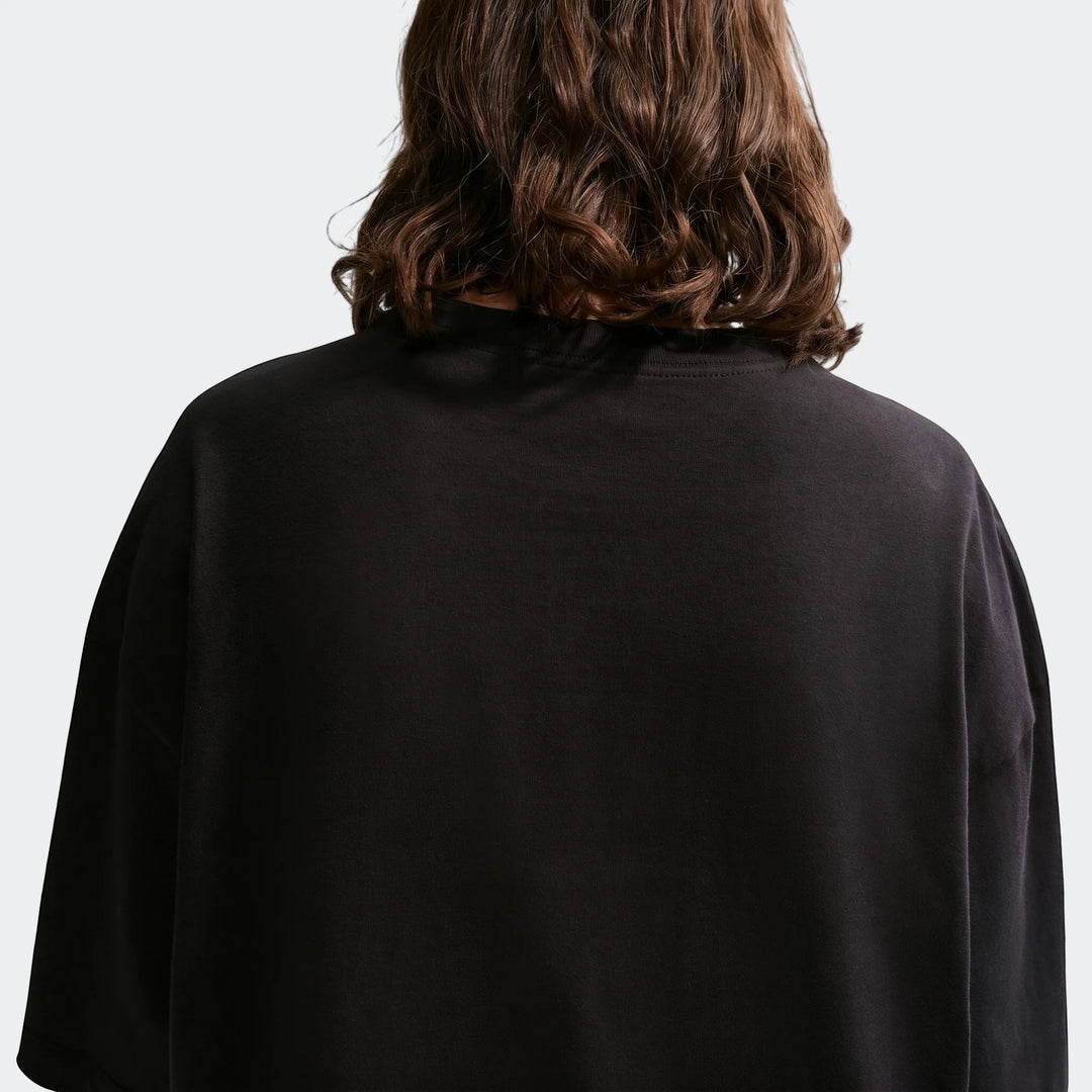 Nike Sportswear Classic black oversized women's t-shirt, styled from the back with a person's wavy brown hair.