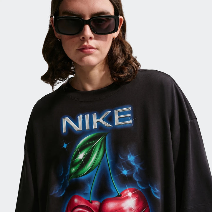 Nike Sportswear Classic oversized t-shirt for women in black, featuring a vibrant 'NIKE' logo and cherry graphic on the
