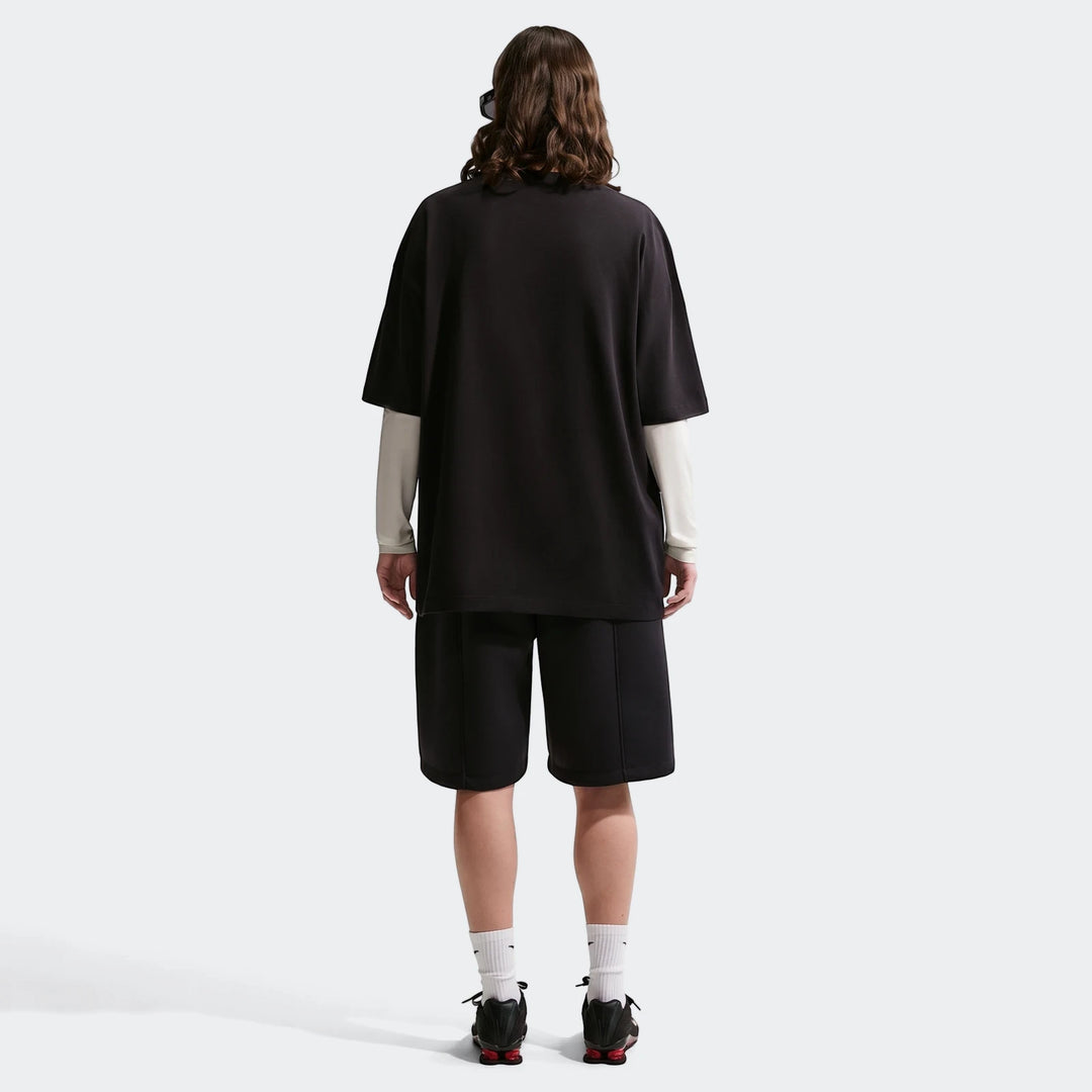 Women's Nike Sportswear Classic oversized t-shirt in black, styled with black shorts, viewed from the back.