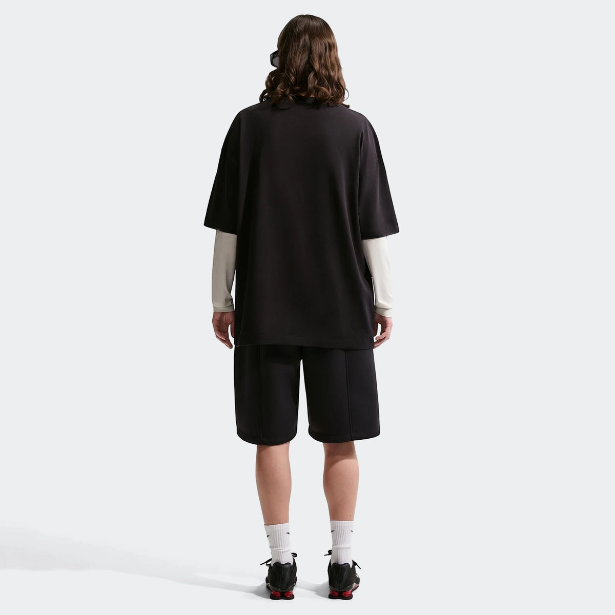 Women's Nike Sportswear Classic oversized t-shirt in black, styled with black shorts, viewed from the back.