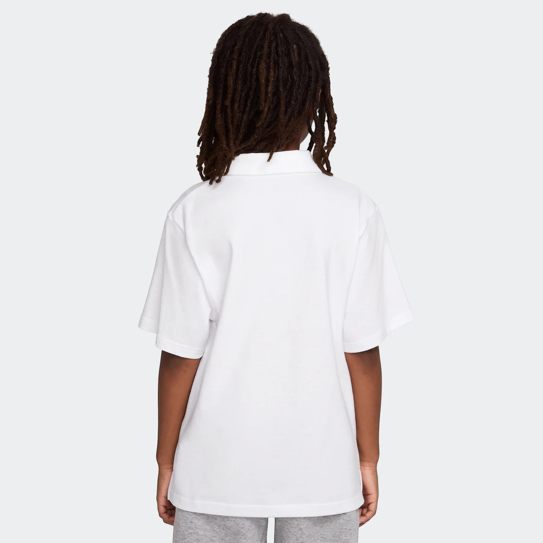 Back view of a young person wearing a white Nike Sportswear Club Big Kids' Knit Short-Sleeve Polo.