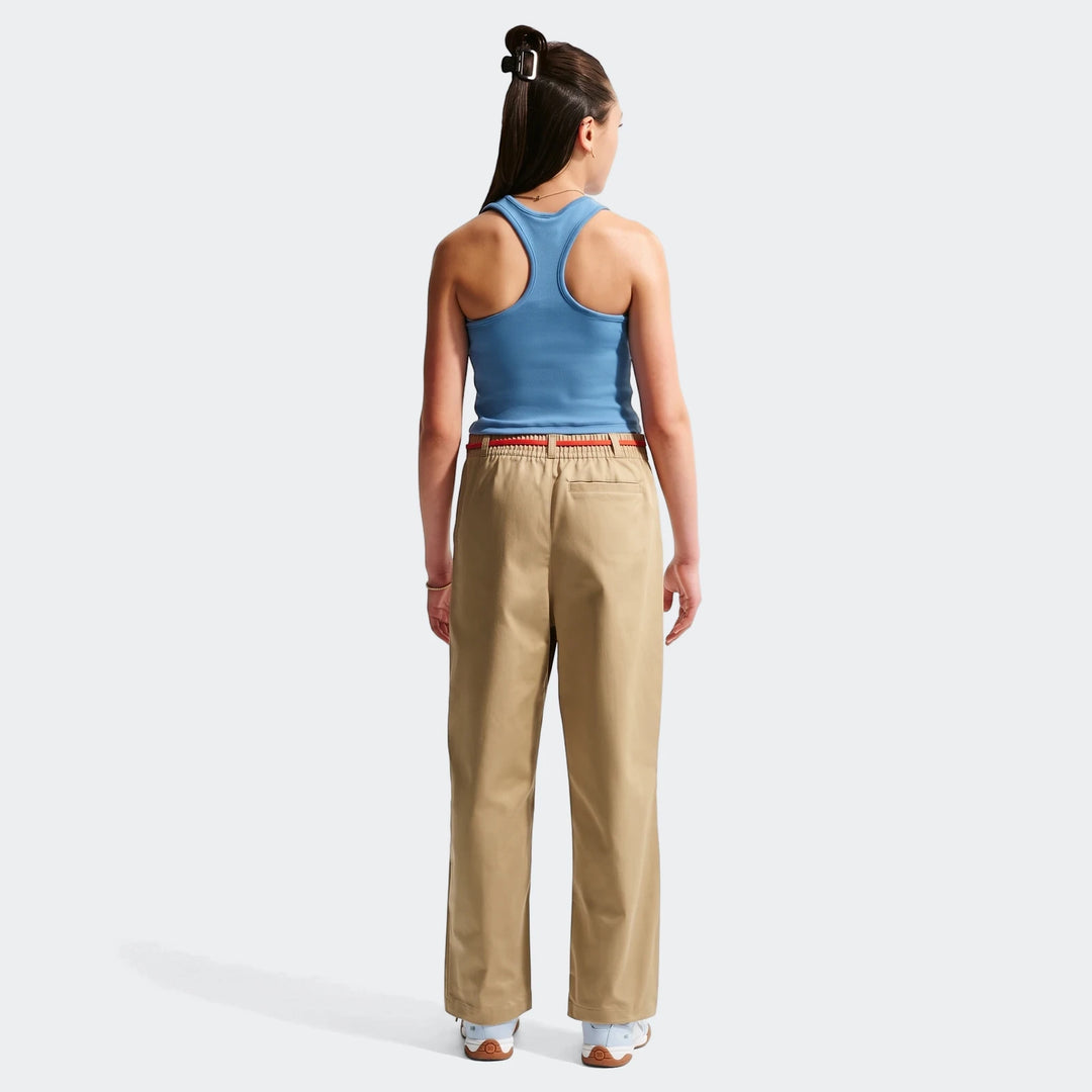Full back view of a person wearing Nike Sportswear Club Big Kids' Woven Everyday Pants in khaki with a blue ribbed tank top.