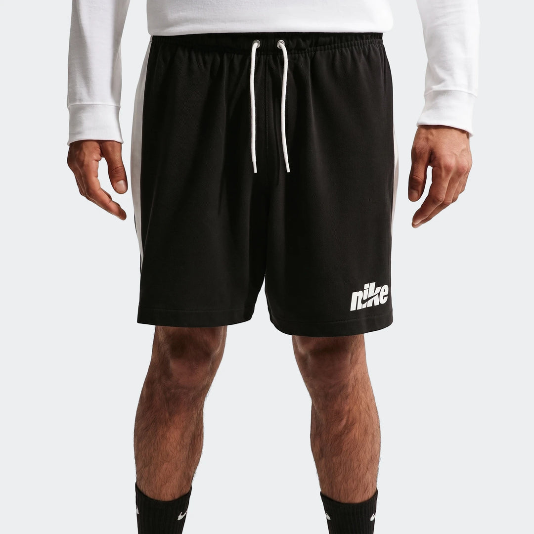 Nike Sportswear Club men's black knit flow shorts with white side stripes and Nike logo, worn by a model.