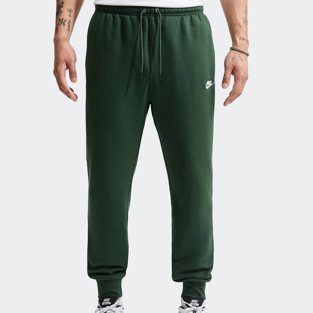 Dark green Nike Sportswear Club Men's Joggers worn by a model, featuring a drawstring waist and cuffed ankles.