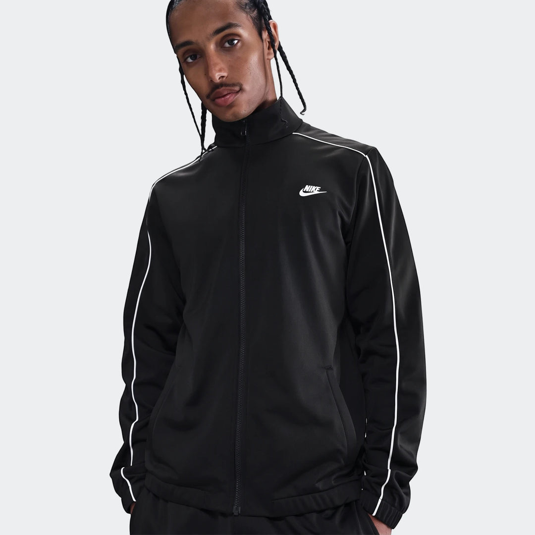 Male model wearing a black Nike Sportswear Club Poly-Knit Tracksuit jacket with white piping, shown from the waist up.