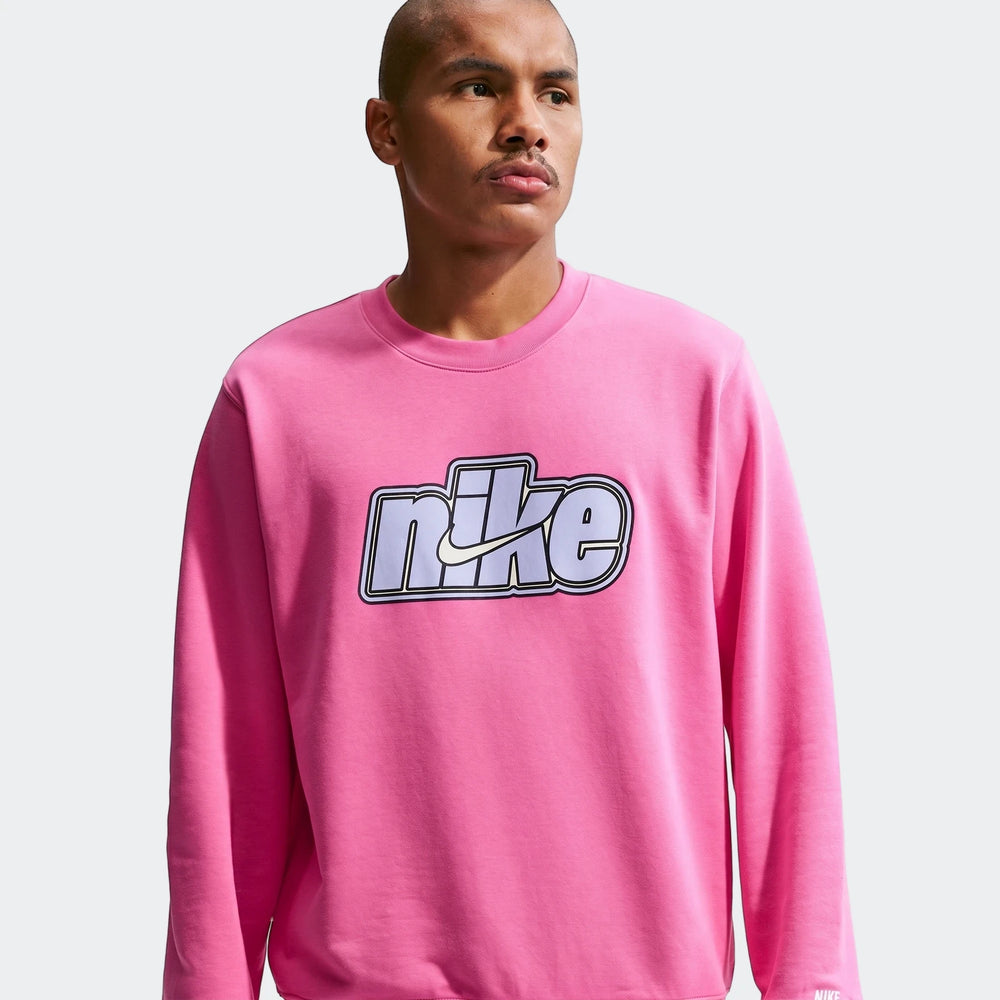 A man wears a pink Nike Sportswear Club Red French Terry crew-neck sweatshirt, featuring a prominent logo on the chest.