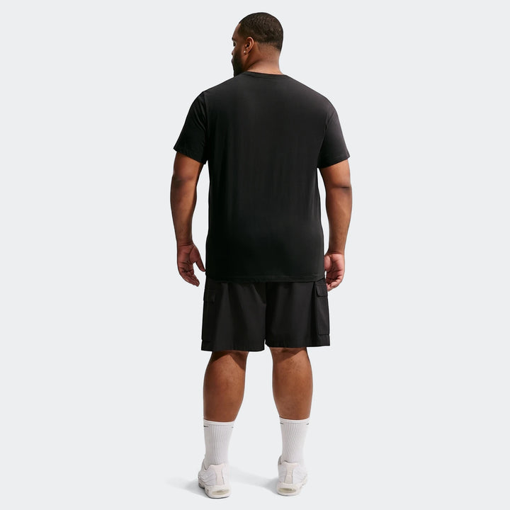 Black Nike Sportswear men's short-sleeve t-shirt, worn by a man from the back, paired with black cargo shorts and white