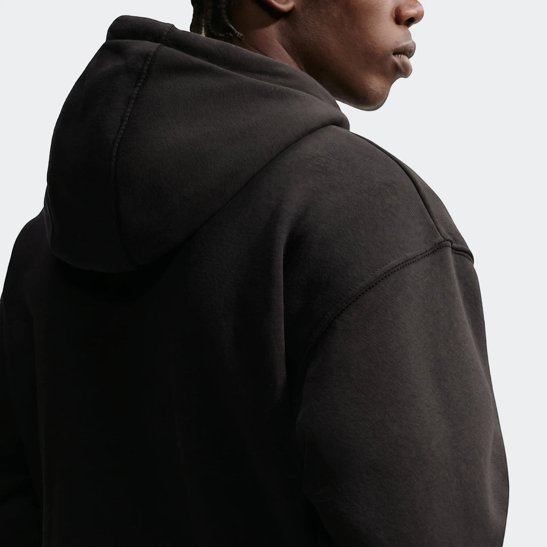 Nike Sportswear Men's Pullover Hoodie in black, worn by a model in a close-up back view, showing the fabric texture and