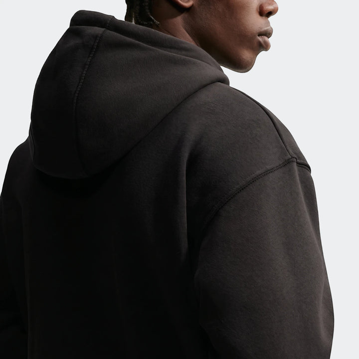 Nike Sportswear Men's Pullover Hoodie in black, worn by a model in a close-up back view, showing the fabric texture and