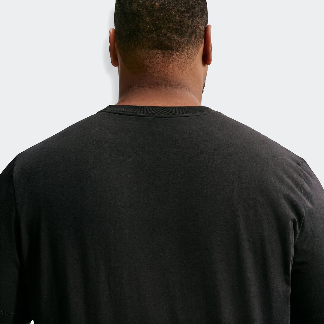 Back view of a man wearing a black Nike Sportswear men's crew-neck t-shirt, showcasing the fabric texture.