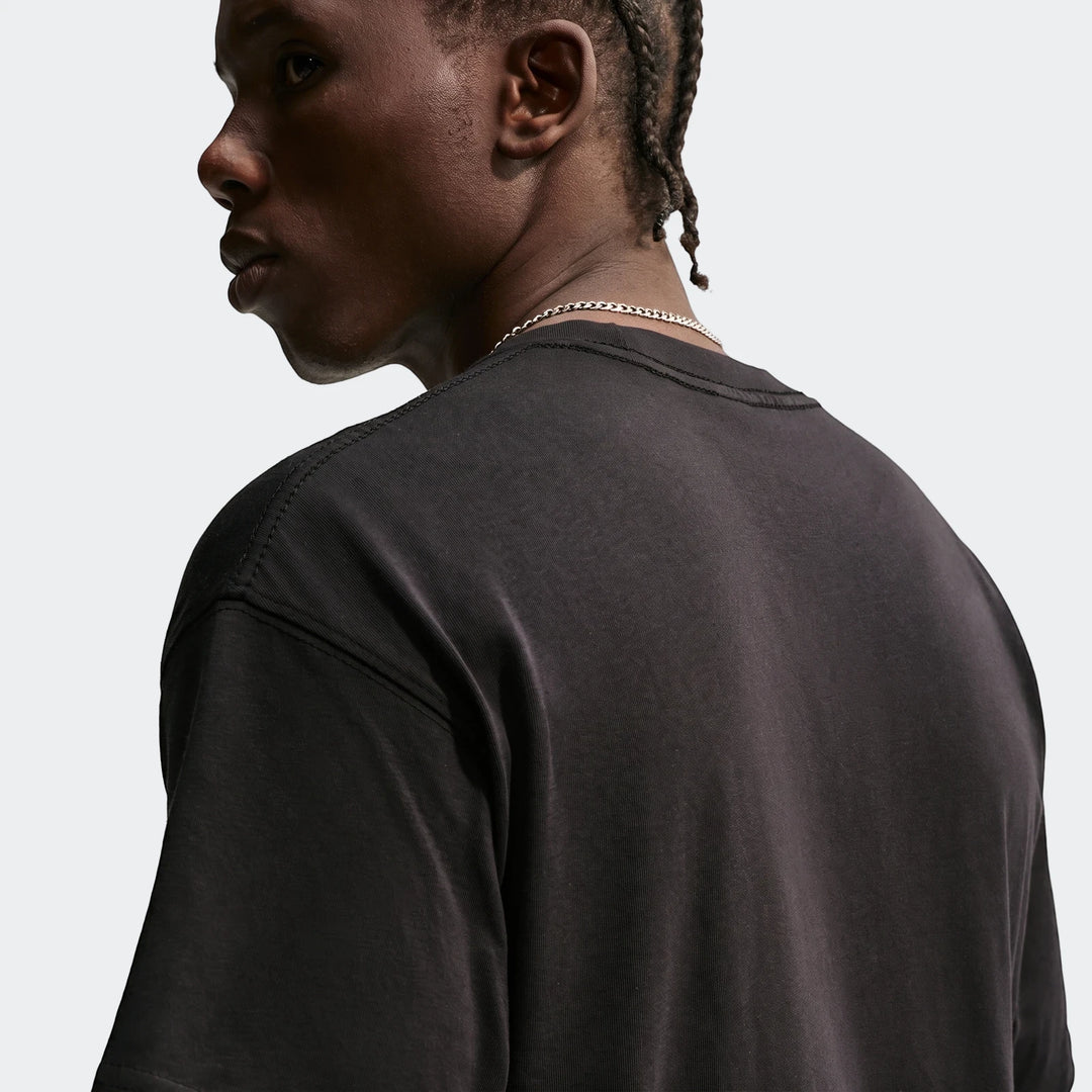 Nike Sportswear Men's T-Shirt in black, modeled from the back to highlight the fit and fabric.