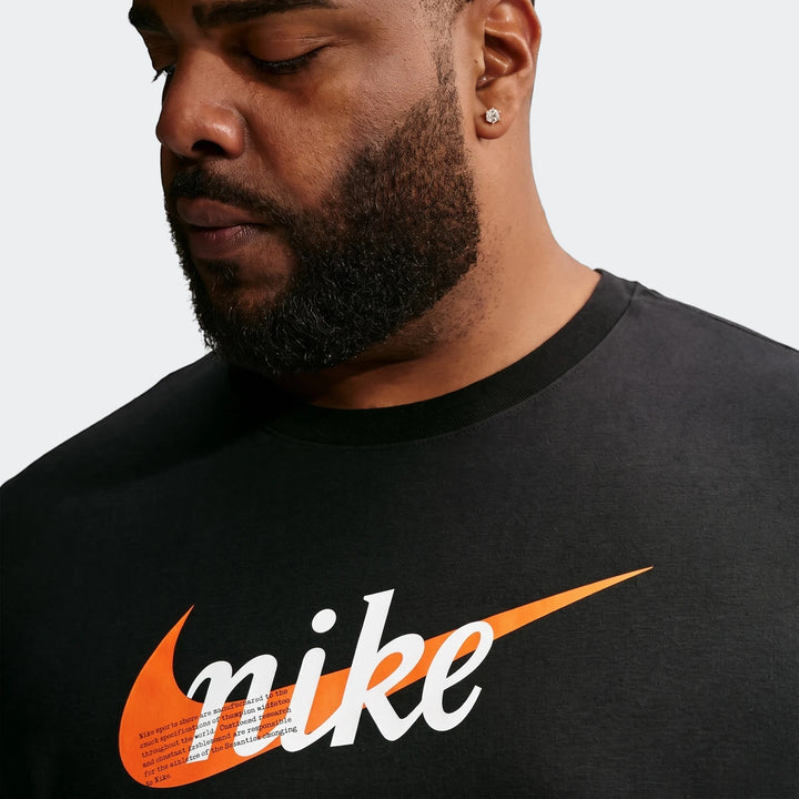 A man in a black Nike Sportswear t-shirt featuring a white 'nike' logo and orange swoosh, looking down.