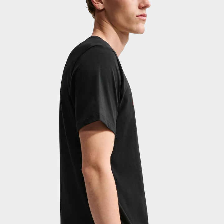 Nike Sportswear Men's T-Shirt in black, short sleeves, worn by a male model in a side profile view.