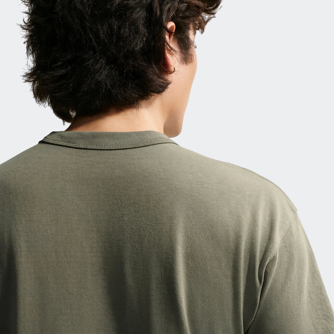 Nike Sportswear Premium Essentials men's t-shirt in green, seen from the back, highlighting the fabric texture.
