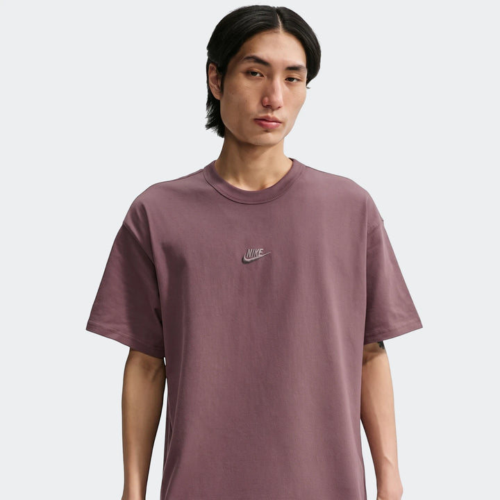Nike Sportswear Premium Essentials men's t-shirt in a dusty rose mauve, worn by a male model in a chest-up view.