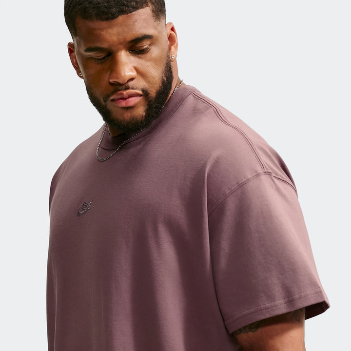 Male model wearing a Nike Sportswear Premium Essentials Men's T-Shirt in a rich mauve color, featuring a subtle Nike logo.