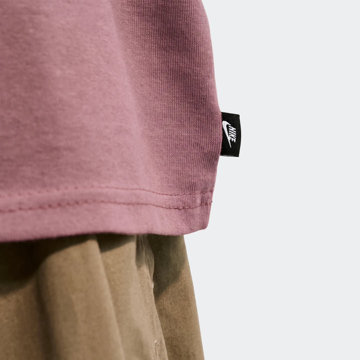 Close-up of a Nike Sportswear Premium Essentials men's t-shirt in pinkish-purple, showcasing its ribbed fabric and a black