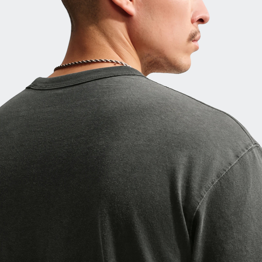 Close-up back and side view of a male model wearing a dark grey Nike Sportswear Premium Essentials T-Shirt with a silver