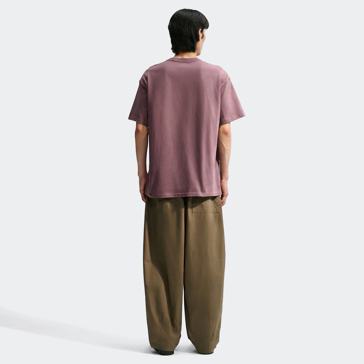 Men's Nike Sportswear Premium Essentials maroon t-shirt, back view. Model wears the t-shirt with olive wide-leg pants.