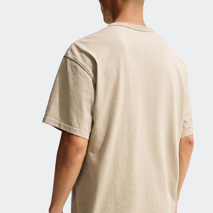 Back view of a men's Nike Sportswear Premium Essentials T-Shirt in beige, showcasing its relaxed fit and soft fabric.