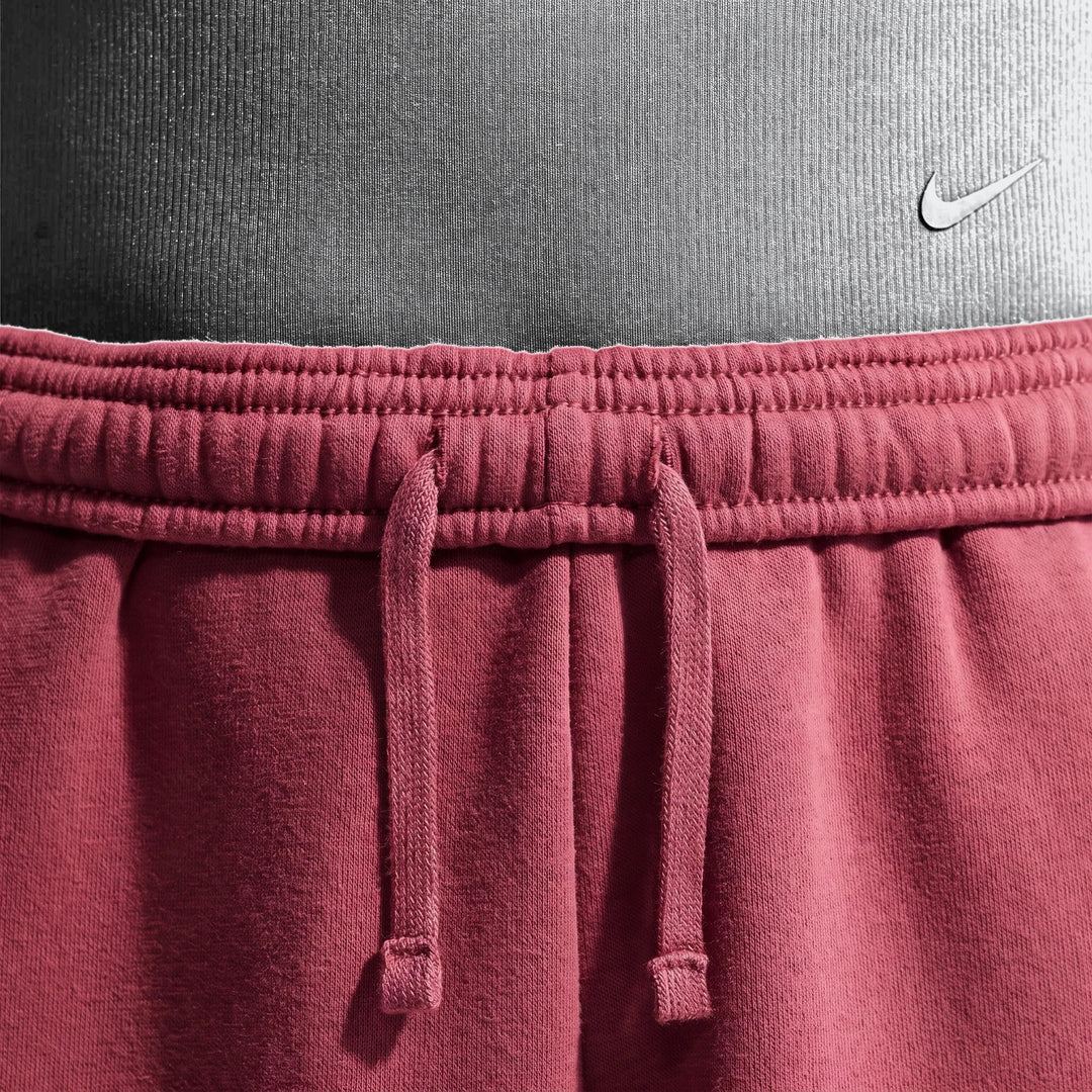 Close-up of Nike Sportswear Studio Fleece Girls' Loose Pants in maroon, showcasing the elastic waistband, drawstring, and