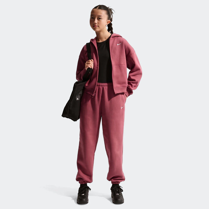 Young girl wearing a full Nike Sportswear Studio Fleece outfit in mauve, including a zip-up hoodie and loose-fit pants,