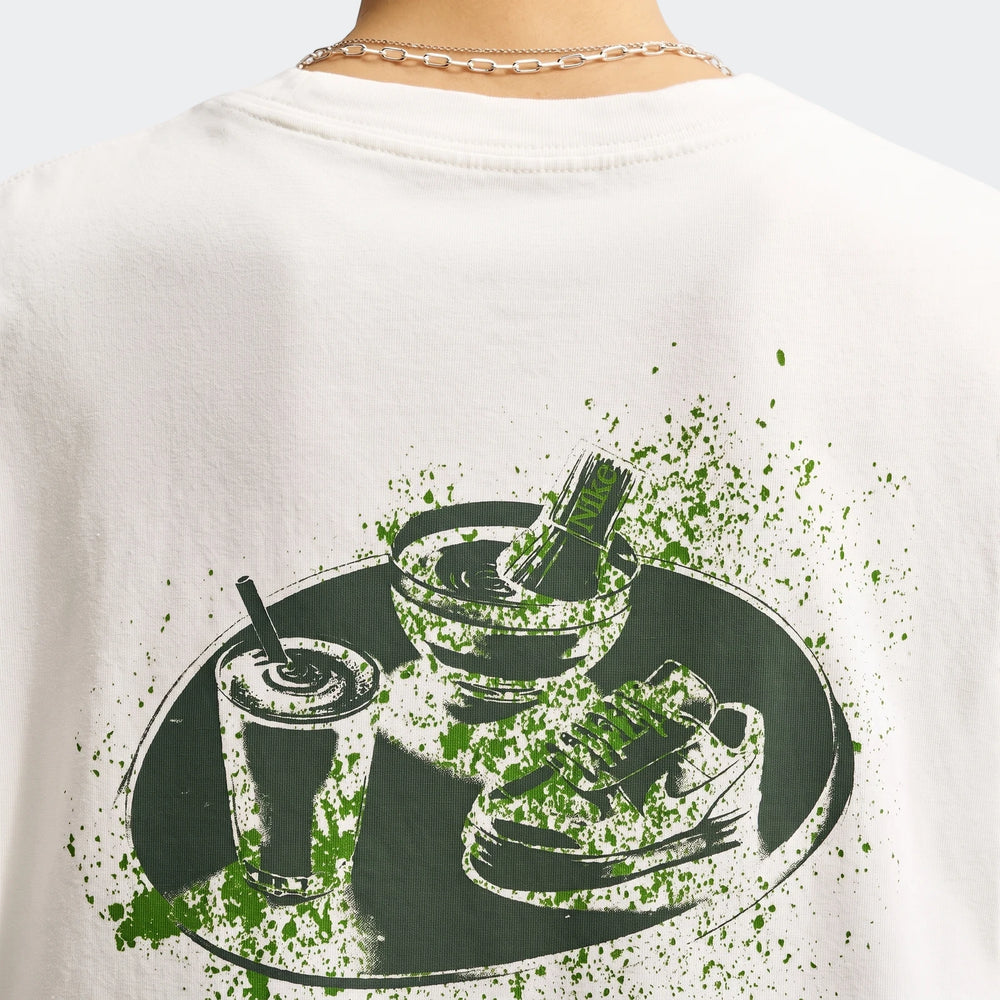 Close-up of the back of a white Nike Sportswear Women's Oversized T-Shirt, featuring a unique green graphic print.