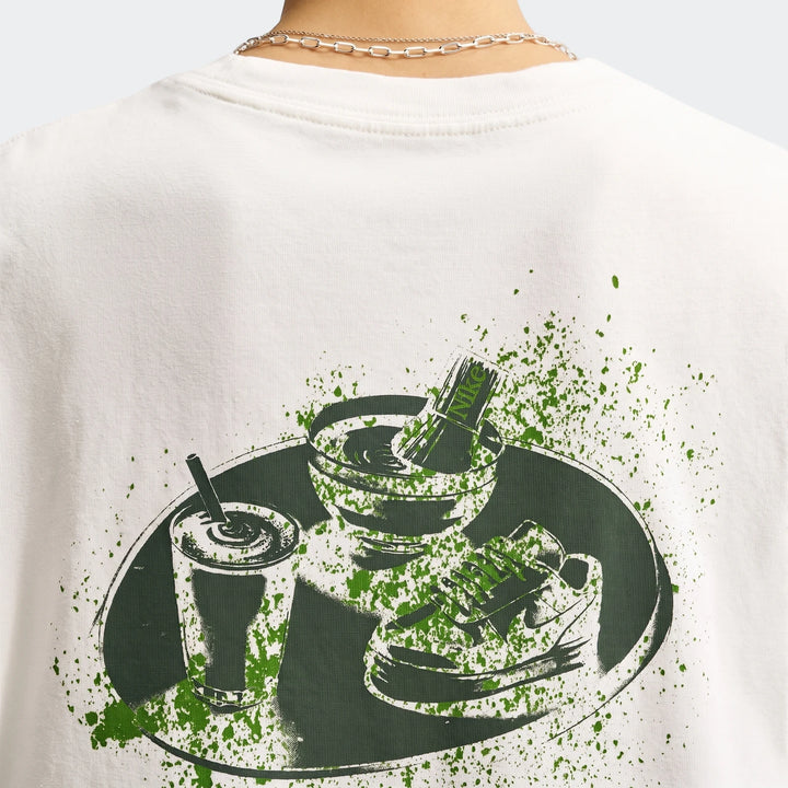 Close-up of the back of a white Nike Sportswear Women's Oversized T-Shirt, featuring a unique green graphic print.