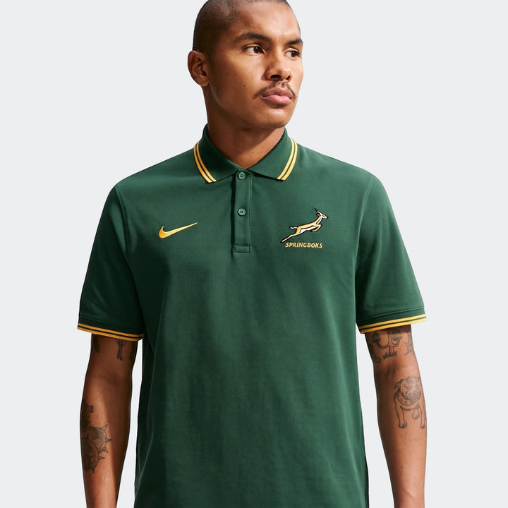 Male model wearing a green Nike Springboks Pique Polo Golfer shirt with gold striped collar and cuffs, shown in a front view.
