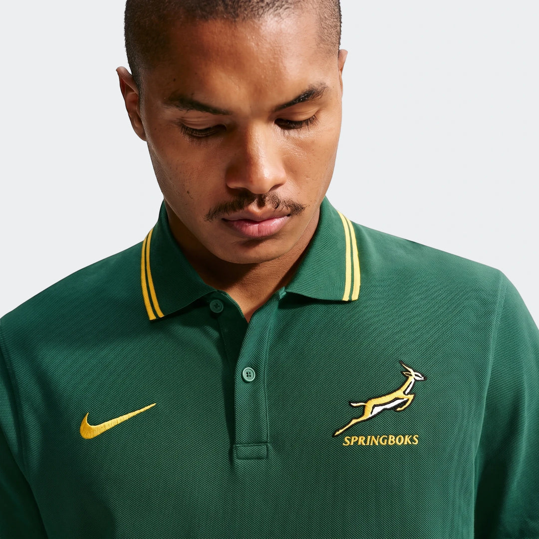 Man wearing a green Nike Springboks pique polo golfer with gold accents, captured in a close-up studio shot.