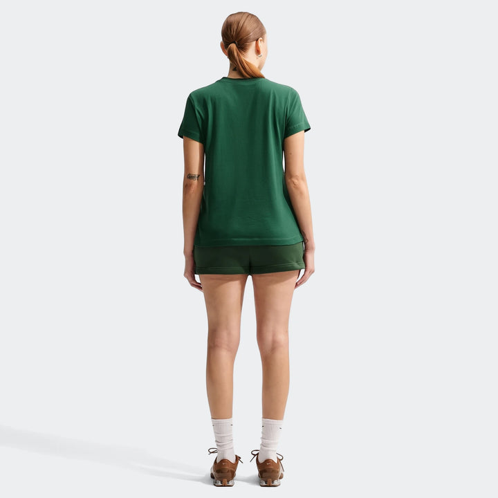 Woman wearing a 2026 Nike Springboks Rugby’S Greatest Rivalry Tour Women T-Shirt in green and dark green shorts, viewed from