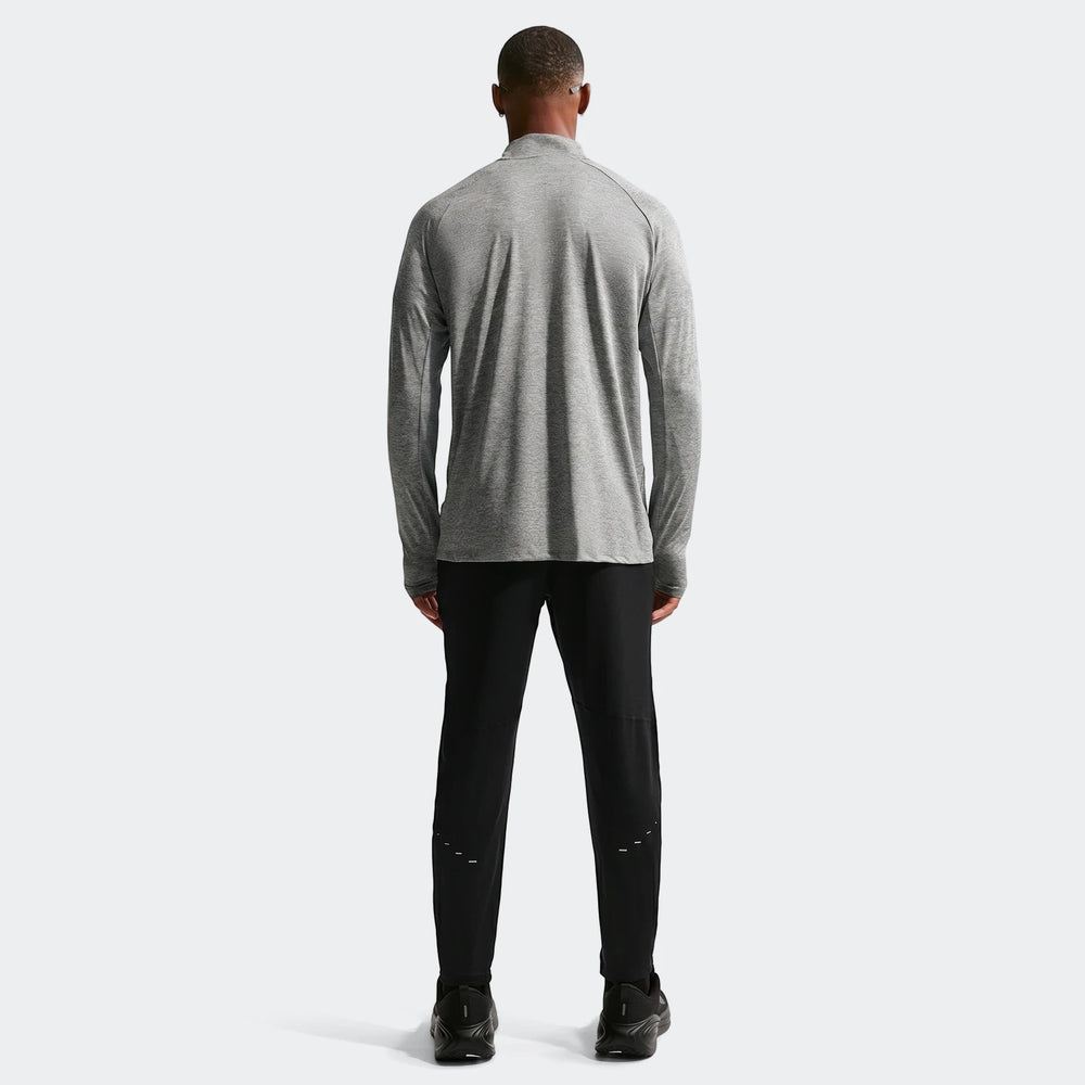 Rear view of a man wearing a grey Nike Stride Dri-Fit 1/4-Zip running top and black running pants.