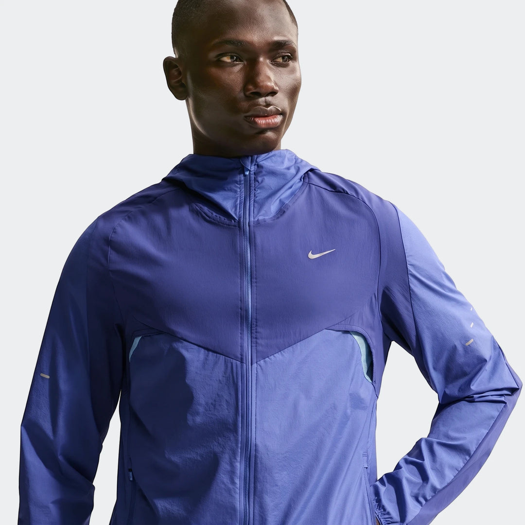 Blue Nike Stride Plus Men's Repel Running Jacket worn by a model in a half-body view, featuring a hood and two-tone design.