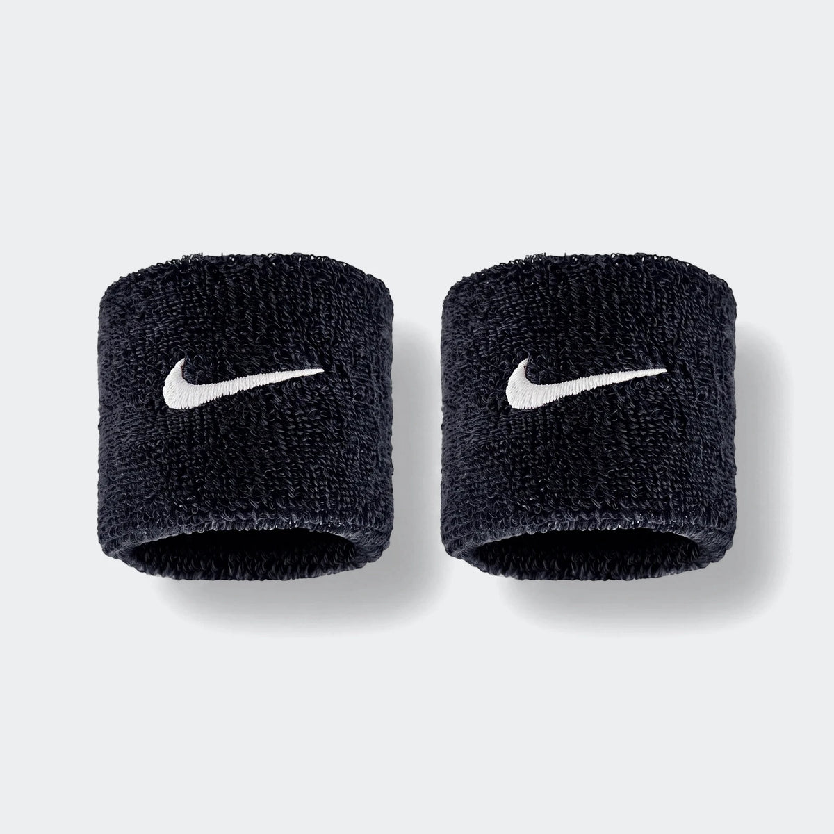 A pair of black Nike Swoosh Classic D terry cloth wristbands with white embroidered logos, shown side by side.