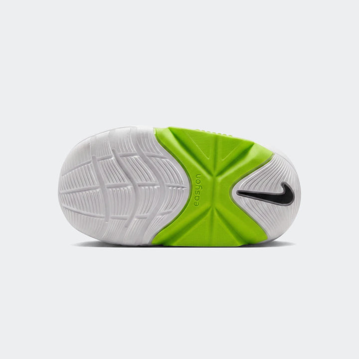 Bottom view of white Nike Swoosh Go baby/toddler shoes, featuring a bright green mid-sole and black Swoosh logo.