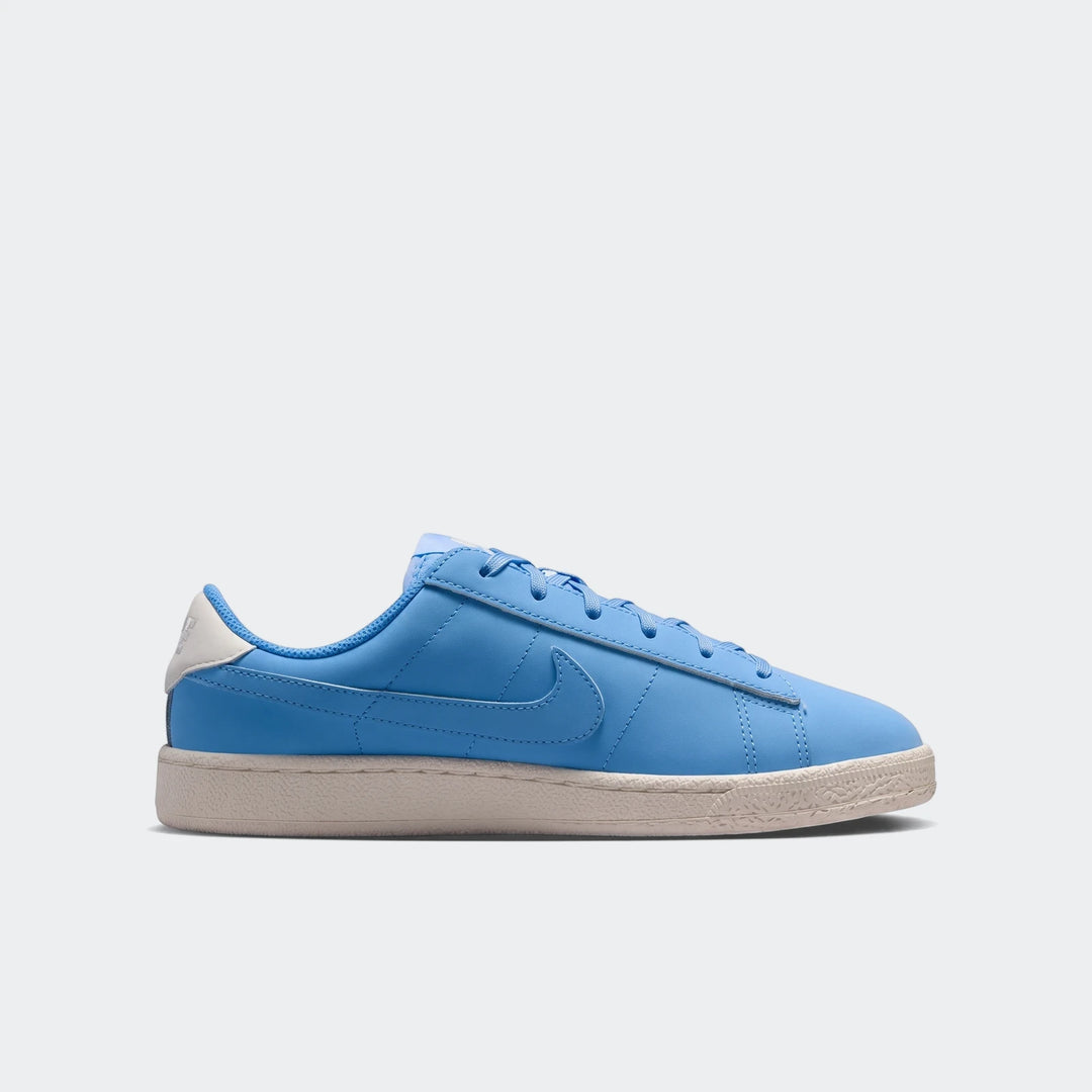 Blue Nike Tennis Classic Big Kids' shoes with an off-white sole, shown in a side profile.