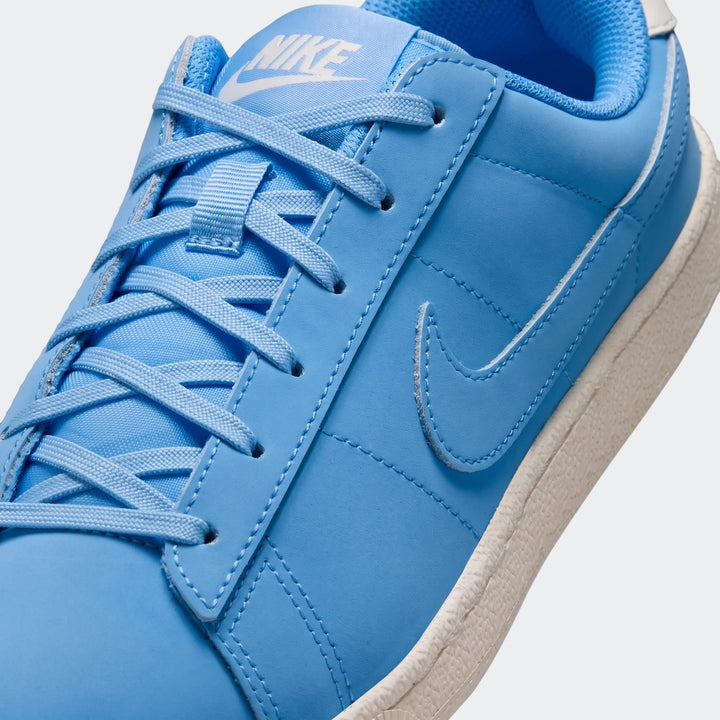 Close-up of a blue Nike Tennis Classic Big Kids' shoe, featuring white laces and the iconic white swoosh logo on the side.