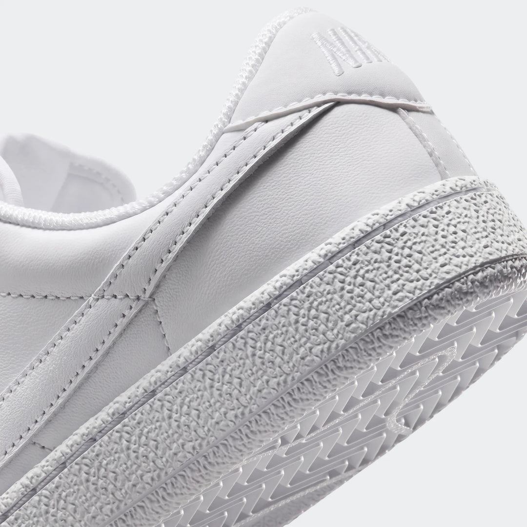 Close-up of the white Nike Tennis Classic Big Kids' shoe, showing the heel, textured midsole, and sole tread pattern.