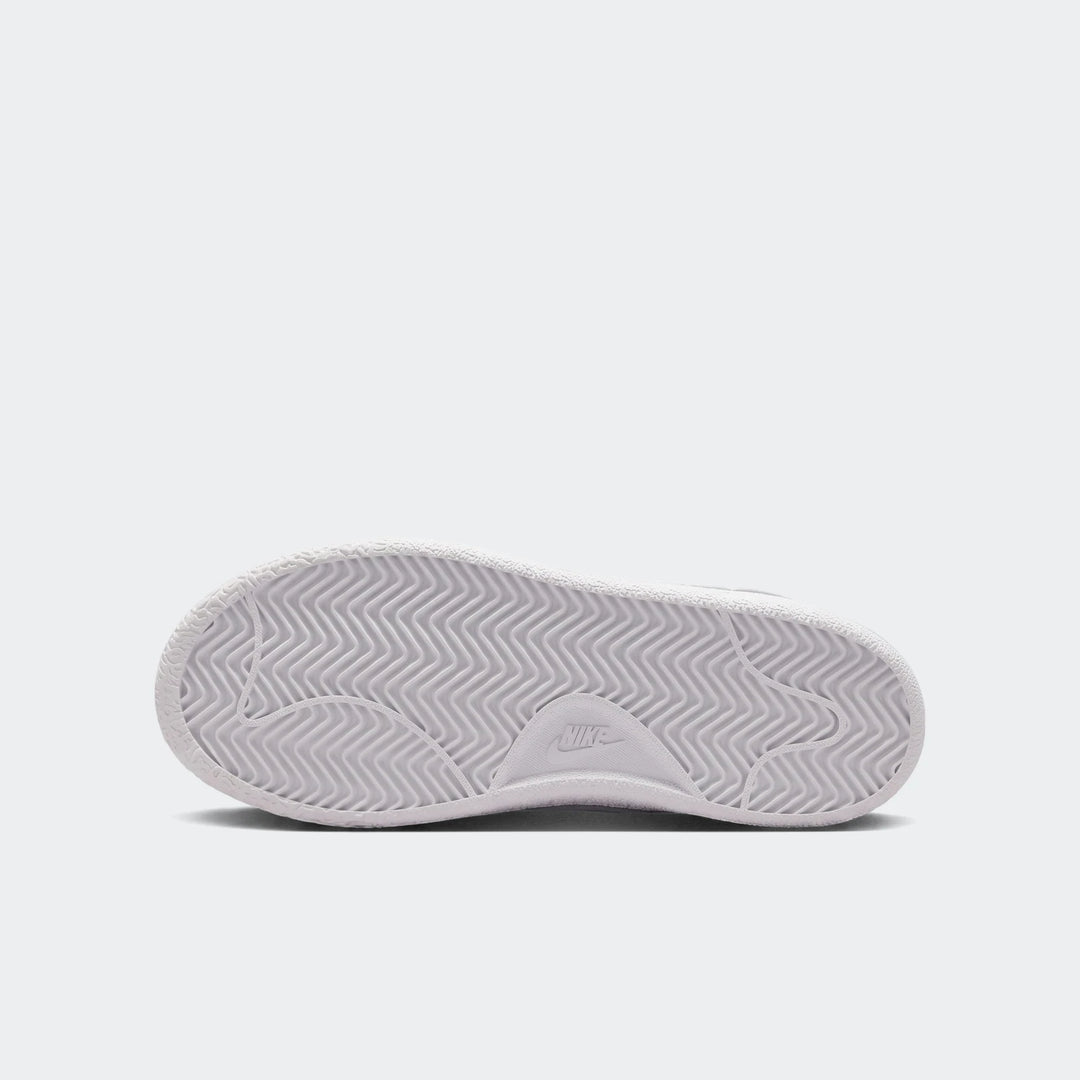 White Nike Tennis Classic Big Kids' shoe sole, showing the textured outsole and wavy traction pattern in a top-down view.